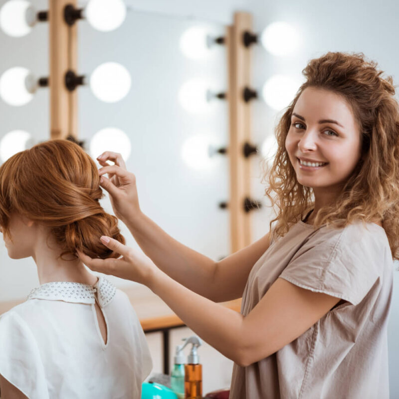 female-hairdresser-smiling-making-hairstyle-redhead-woman-beauty-salon
